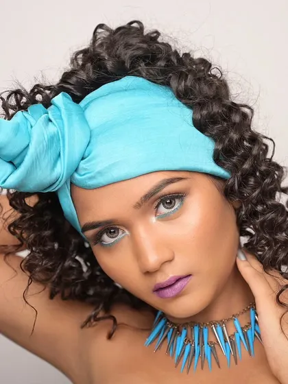 This pose highlights the volume and texture of the curly hair.