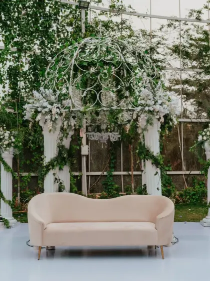 A beautiful and elegant white gazebo setup in a garden, creating a picture-perfect spot for a reception or photo booth.