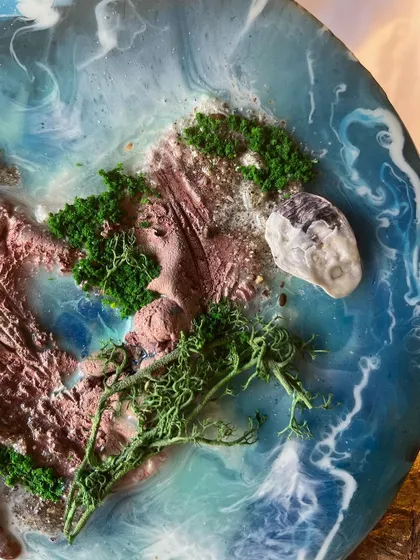 The details matter. I use natural elements like moss, sand, and tiny shells to create realistic and textured landscapes within my resin art.