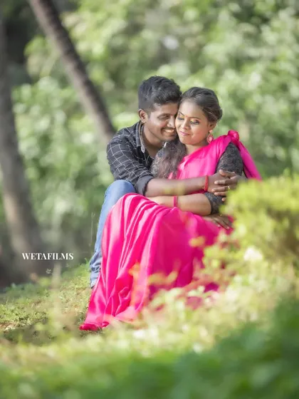 A tender hug amidst the greenery. This pre-wedding photo captures a quiet, peaceful moment of connection between the couple in a beautiful park setting.