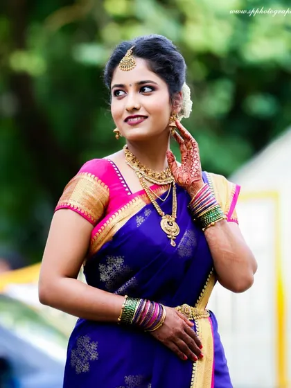An elegant outdoor bridal portrait. We capture the bride looking her absolute best, highlighting the vibrant colors of her saree and her graceful pose.