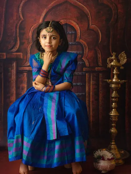 A stunning solo portrait of a young girl dressed in a beautiful blue saree for a festive occasion.