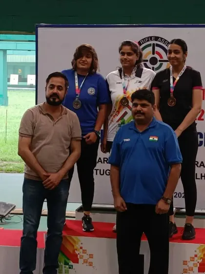 Posing with another group of accomplished female shooters on the podium after presenting their medals.