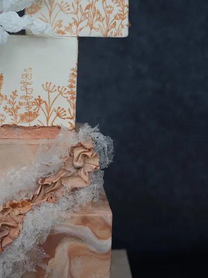 Master modern techniques like mesh stenciling and creating flexible wafer paper lace. This detailed shot from our Tiered Elegance class shows the beautiful, fabric-like effects you can achieve.