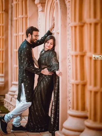 A romantic pose against a backdrop of pillars. The couple's all-black outfits create a very chic and sophisticated look.