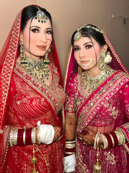 Sisters before misters. A beautiful portrait of the two sister brides, one in red and one in pink, both looking absolutely radiant.