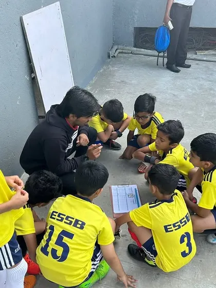 A coach giving a tactical talk to the U8 team during the Blues Super Cup. Strategy and quick adjustments are key to winning tournaments.