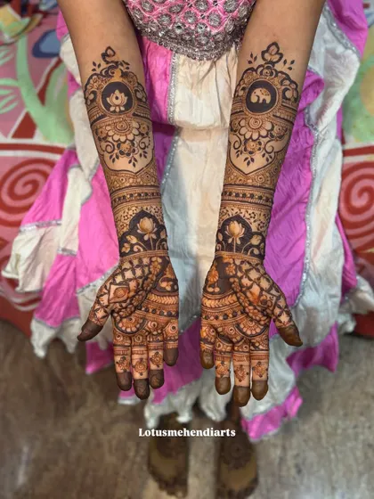 A beautiful bridal design featuring lotus and elephant medallions on the back of the hands, combined with intricate patterns on the palms for a complete bridal look.