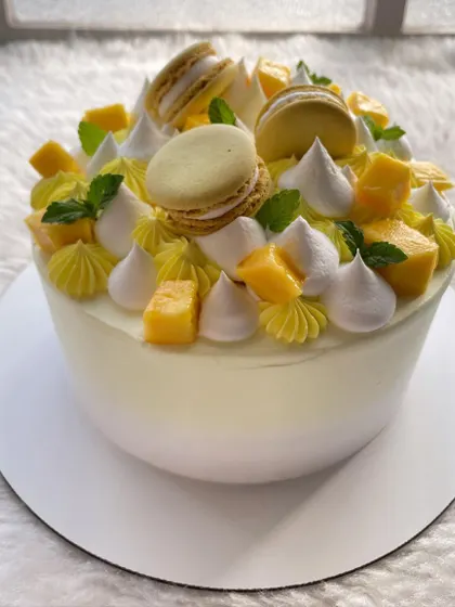 A celebration of summer with this fresh mango cake. It's topped with mango macarons, meringue kisses, and of course, lots of fresh mango chunks.