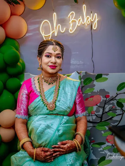 A lovely seated portrait of the mother-to-be, looking calm and happy in front of the neon sign.