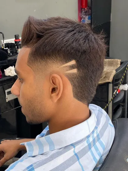 A clean profile view of a fade with a double-triangle hair tattoo. The design is placed just above the ear for a subtle yet stylish detail.