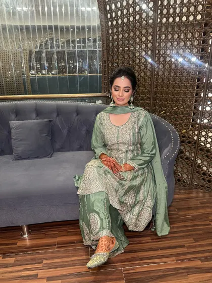 A full view of the Mehndi look, showing how the simple, elegant makeup allows her natural beauty and colorful outfit to shine.