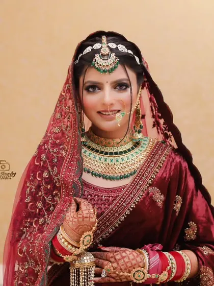 A full-length portrait of a bride in a beautiful velvet lehenga. She looks radiant and ready for her big day.