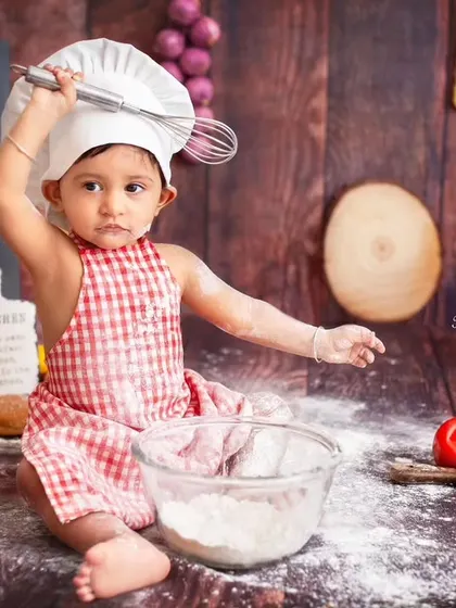 A master chef in action, whisking with flair. I love capturing the playful spirit of babies during these themed shoots.