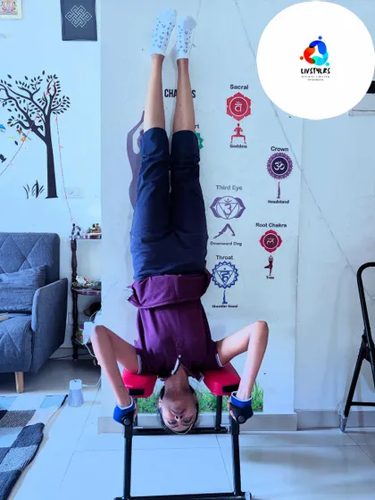 A client practices a headstand using a specialized bench, which allows for safe inversions that decompress the spine.