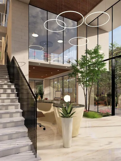 The double-height reception area концепт for Nandi Souls, a boutique weekend home project in Bangalore. The design uses natural light, indoor greenery, and a grand staircase to create a welcoming sense of arrival.