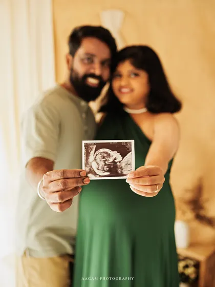 The first family photo. The couple proudly holds up their baby's ultrasound picture, a key moment in their pregnancy journey.