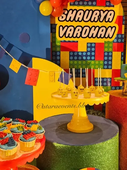 A close-up of the themed treats, including LEGO head cake pops and cupcakes topped with colorful edible bricks.