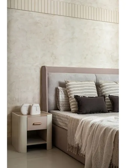 Detail of the textured wall paint and custom bedside table in the same guest room.