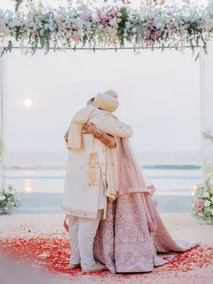 A heartfelt hug between the bride and groom at their beach wedding ceremony. A simple, powerful expression of love and commitment.