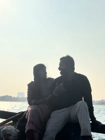A candid shot of a couple enjoying a conversation during their sunset boat ride. The soft light and calm water create a truly romantic atmosphere.