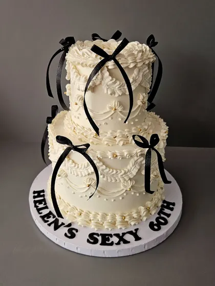 This one is for the lovers of all things classic. A two-tier vintage Lambeth cake with intricate buttercream piping and delicate black ribbon bows. This style is all about elegance and old-world charm, making it an *ati sundar* choice for a milestone birthday or chic celebration.