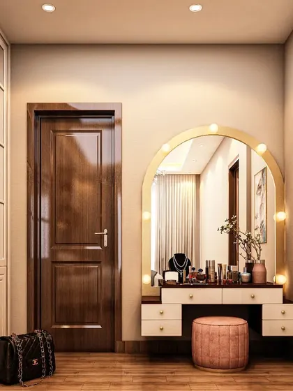A chic dressing corner featuring a large, arched mirror with classic vanity lights. The simple white dressing table and pink stool create a clean and feminine space, perfect for any bedroom.
