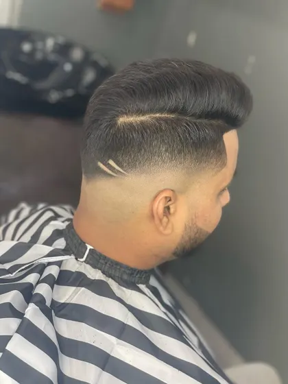This angle shows the clean partition and the sharp fade. The geometric design is subtle but adds a custom element to this polished haircut.