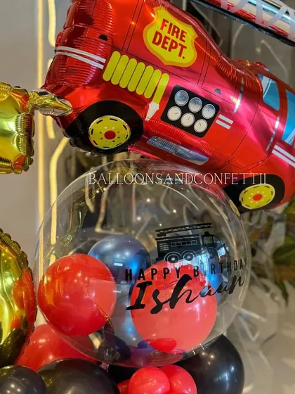 A detailed shot of the personalized bubble balloon from the firetruck bouquet, featuring a custom message for Ishaan's birthday.