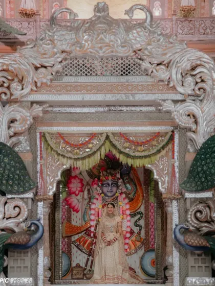 Radhika standing before the magnificent Shrinathji deity. This powerful image connects the spiritual and the personal, showing a moment of reverence and peace before the wedding ceremony begins.