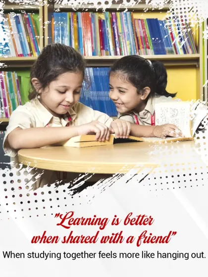 Learning is always better when shared with a friend. Two students collaborate in the library, turning study time into a moment of shared discovery.