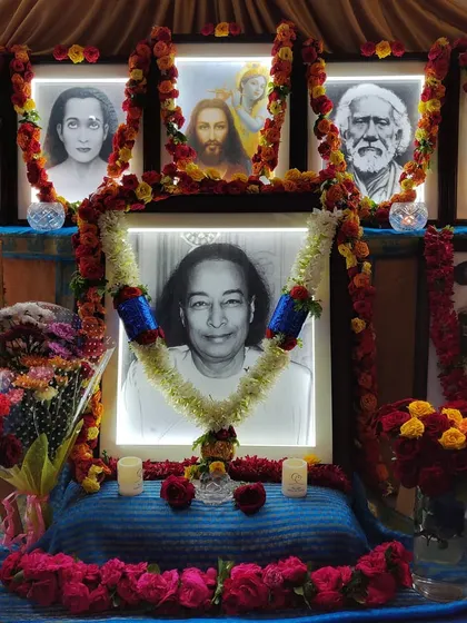 Our main altar, decorated with garlands of roses and illuminated with soft light. This is the spiritual heart of our temple, where we focus our devotion on Paramhansa Yogananda and the masters who guide us.
