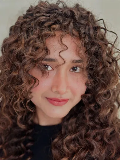 These curls don't follow rules, they make them. A close-up shot of beautifully defined, colored curls.