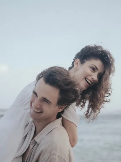 A moment of pure, uninhibited laughter and joy. This candid shot from a Bali beach captures the playful side of the couple's relationship, feeling natural and full of life.