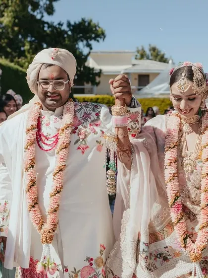 The happy couple, Sanskaara and Priyank, walk hand-in-hand after their ceremony, surrounded by their loved ones in the sunny hills of Ooty.