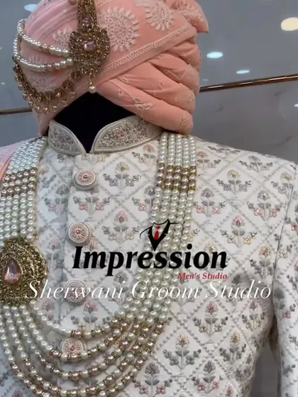 This white sherwani features delicate floral embroidery in peach and green, perfectly coordinated with a peach-colored safa. It’s a great example of how I can match the groom's outfit to the bride's lehenga.