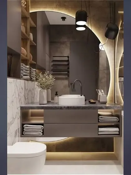 A bathroom design featuring dramatic lighting and a mix of marble and wood textures. The open shelving provides both storage and a place for decorative items.