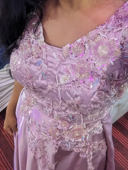 A close-up of the beautiful embroidery on this pastel pink gown. It's a simple yet elegant choice for a party, available to rent or buy.