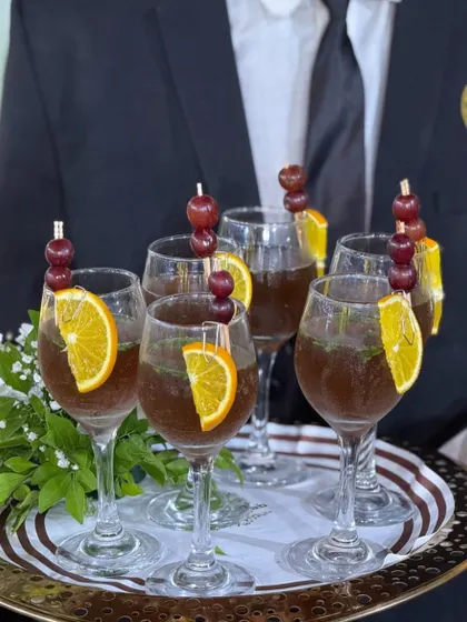 From tangy to sweet, every sip is crafted to delight. A server holds a tray of our elegant mocktails, garnished with fresh fruit, ready to be served to guests.