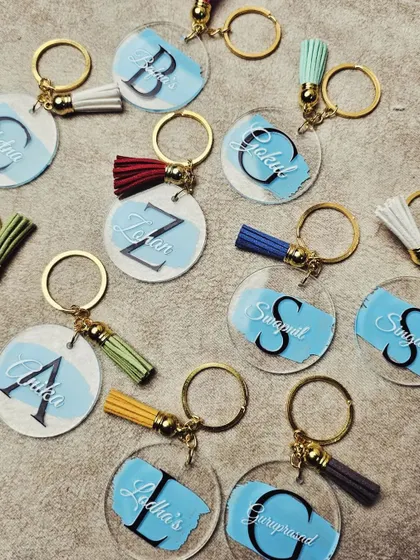 These custom acrylic keychains are a great personalized favor. We can add initials and names, and they come with a colorful tassel, making them a fun and budget-friendly gift.