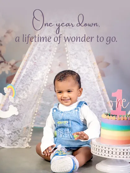 One year down, a lifetime of wonder to go. This sweet moment captures a happy baby girl with her rainbow birthday cake in a whimsical teepee setting, marking her first milestone.