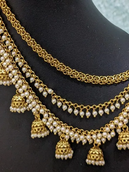 A beautiful multi-layered ear chain with jhumka drops and pearls.