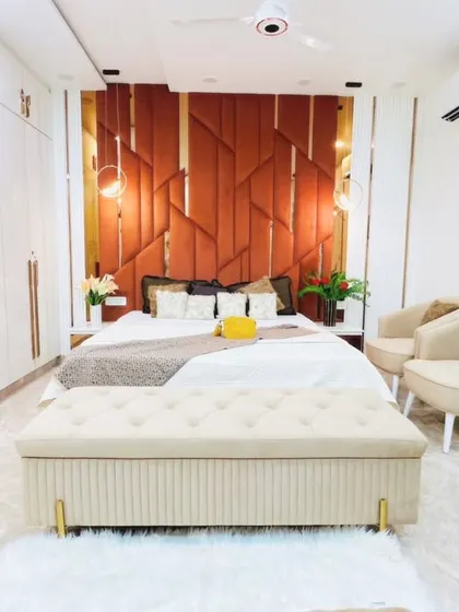 A wider view of the bedroom, showing the full-height glossy white wardrobes that provide ample storage while keeping the room feeling bright and spacious.