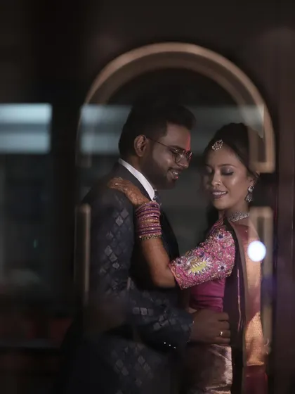 A romantic, through-the-window shot of a couple at their reception or engagement party.
