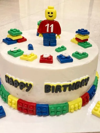 Another fantastic Lego cake, this time for an 11th birthday. The cake is surrounded by a border of colorful fondant bricks.
