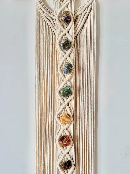 Each stone is securely knotted into place along the central spine of this macrame wall decor.
