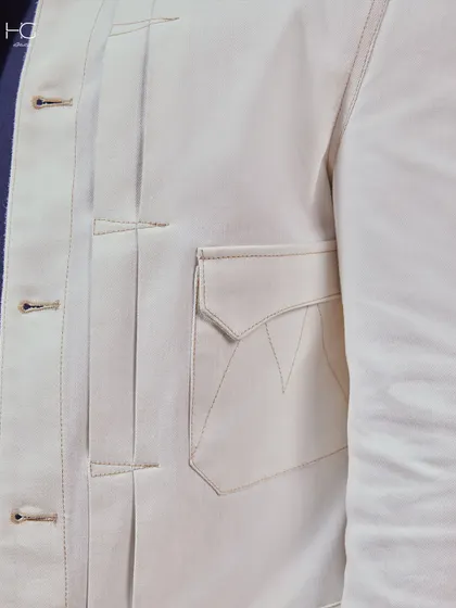 A detail shot of a white jacket, focusing on the structured pleats and pocket stitching. It’s these elements that make my white pieces sleek, structured, and undeniably premium.