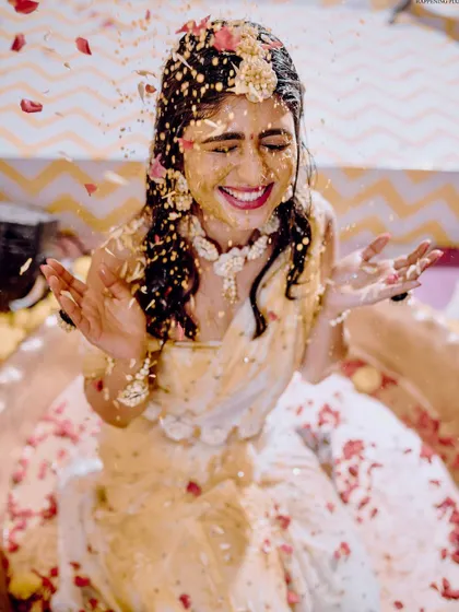 Capturing the pure joy of the Haldi ceremony. The bride is showered with flowers and turmeric, and my decor with its bright yellow drapes and floral accents creates a perfectly festive atmosphere.