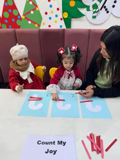 Dressed in their festive best, these girls concentrate on the counting activity. Our themed lessons make learning feel like a celebration, keeping children engaged and excited.