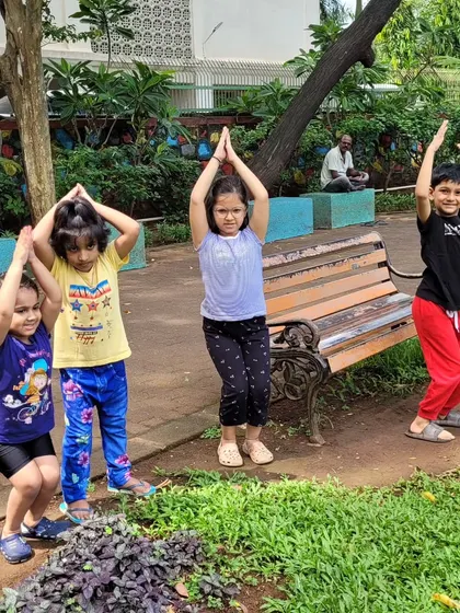 Little yogis practicing tree pose together in the park. Outdoor yoga adds an element of play and connection to the natural world.